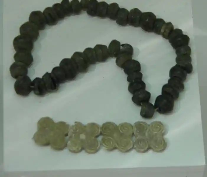 A wooden pendant with four-corner spiral circles forming a cross